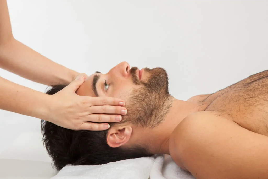 Man ontvangt ontspannende hoofdmassage tijdens Soft Reset Coaching behandeling voor stressvermindering